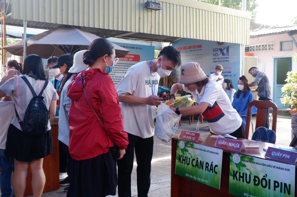 Sau khi đổi rác xong, bà Phượng, sống tại quận Bình Thạnh cùng con trai cầm phiếu đi nhận sách.Ảnh: NGỌC TRĂM