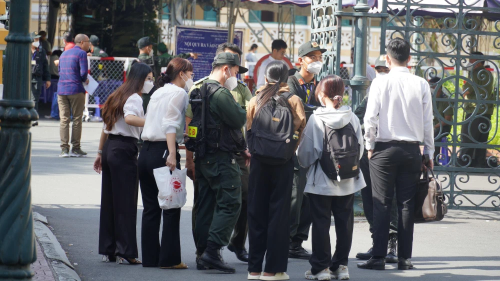 Lực lượng an ninh kiểm tra giấy tờ người ra vào. Ảnh: HỮU ĐĂNG