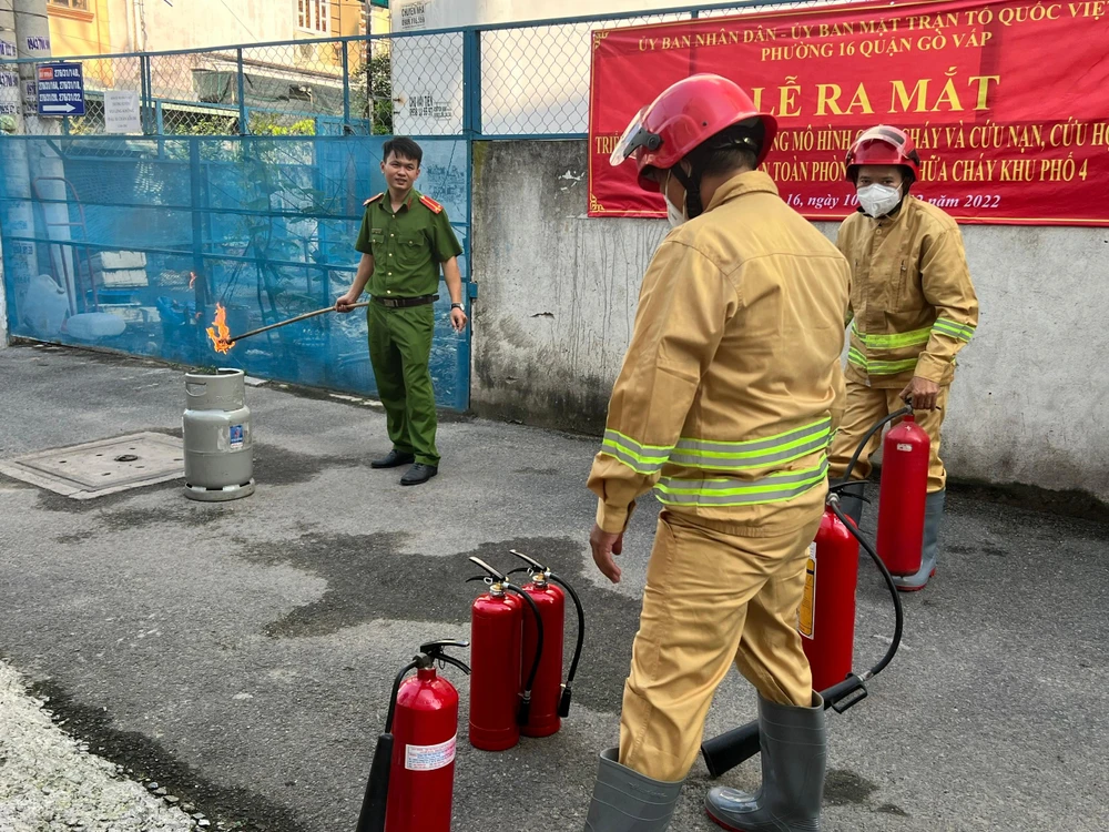 Cán bộ đội PCCC Công an quận Gò Vấp đang chuẩn bị thực hành sử dụng bình cứu hoả để dập tắt đám cháy. Ảnh: ĐẶNG LÊ