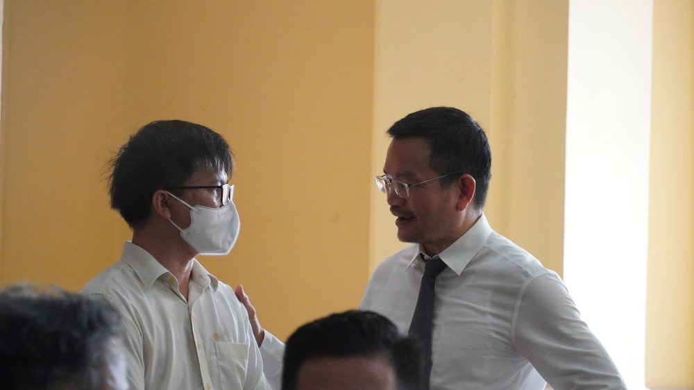 Luật sư của bị cáo Tùng trao đổi với thân chủ trước phiên toà (bị cáo được tại ngoại). Ảnh: HỮU ĐĂNG