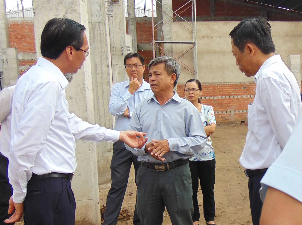 Ông Lê Thanh Liêm (bìa phải) đang trao đổi với đại diện Công ty CP Chế biến thực phẩm Hóc Môn. Ảnh: TRẦN NGỌC