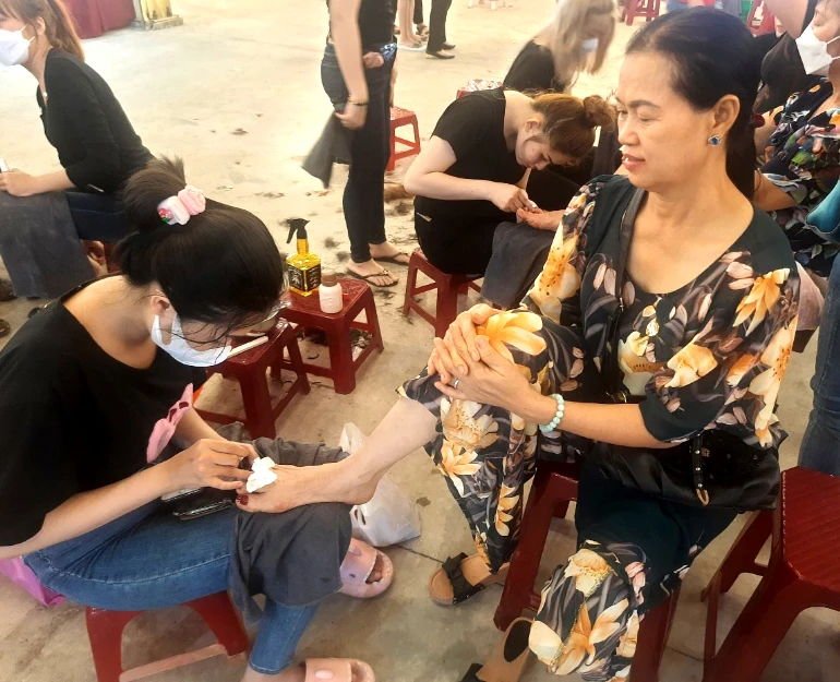 Một chị đang được làm móng miễn phí. Ảnh: TRẦN NGỌC