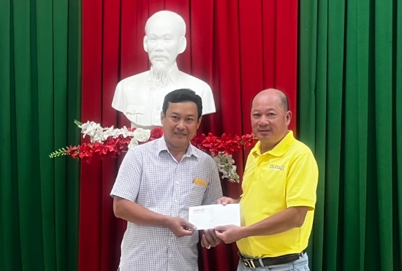 Đại diện UBND xã Tân Thành, huyện Tân Thạnh, Long An (trái) nhận 20 triệu đồng từ đại diện Báo Pháp Luật TP.HCM. Ảnh: THANH NAM