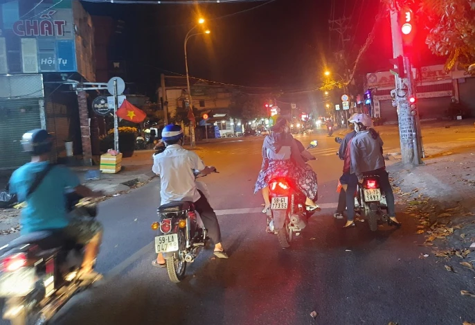 Người đi xe máy kiên nhẫn chờ đèn xanh tại ngã tư Nguyễn Văn Quá - Song Hành. Ảnh: TRẦN NGỌC