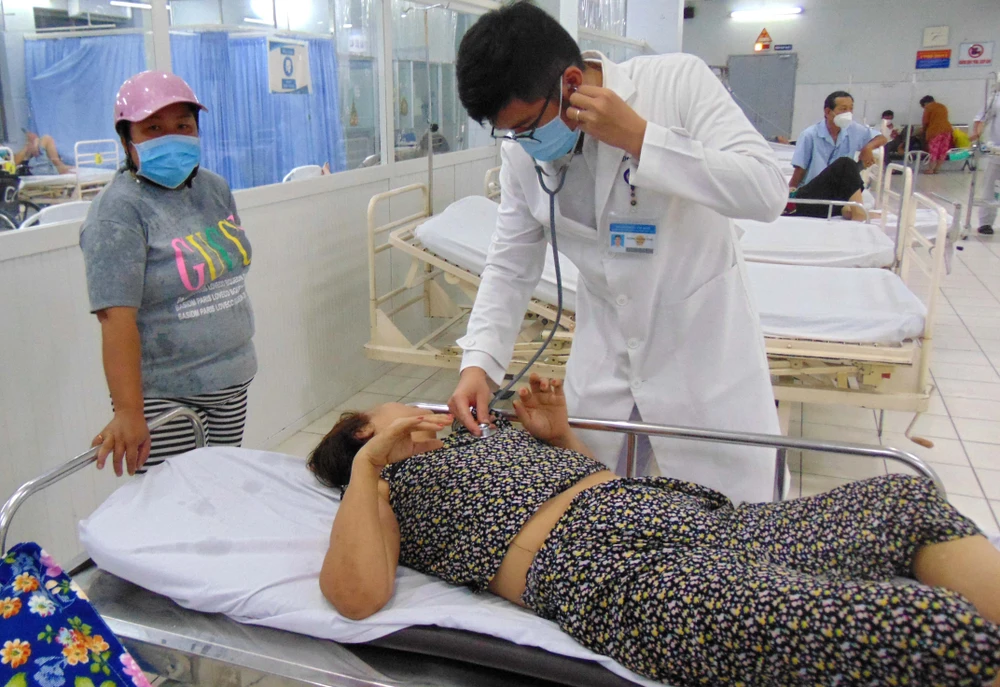 Bác sĩ đang thăm khám ca đột quỵ nặng do đưa tới bệnh viện trễ. Ảnh: TRẦN NGỌC