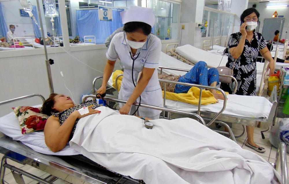 Điều dưỡng Nguyễn Cao Thủy đang đo huyết áp cho một nữ bệnh nhân cấp cứu. Ảnh: TRẦN NGỌC Điều dưỡng Nguyễn Cao Thủy đang đo huyết áp cho một nữ bệnh nhân cấp cứu. Ảnh: TRẦN NGỌC