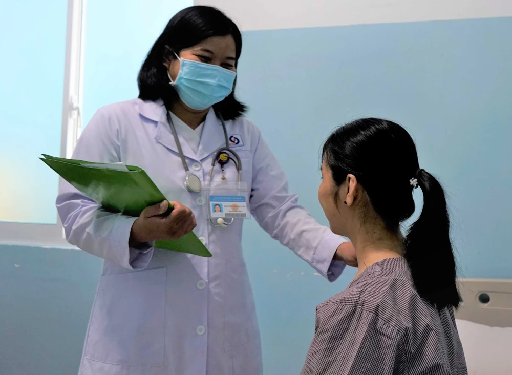Bác sĩ đang kiểm tra sức khỏe chị L sau khi được phẫu thuật. Ảnh: BVCC