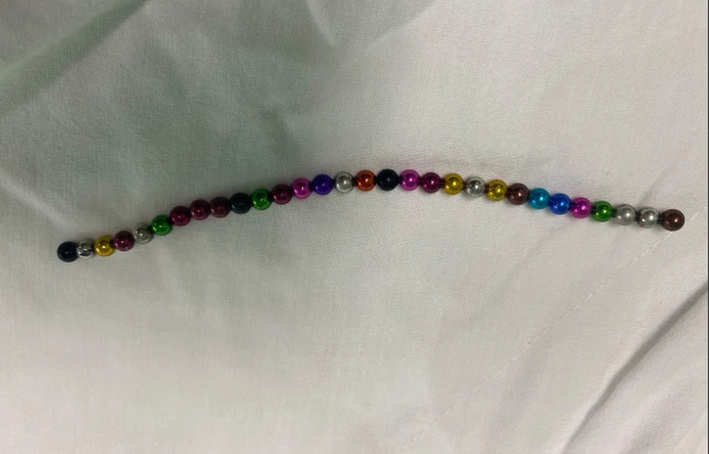 30 viên bi kim loại nhiều màu dính thành chuỗi được các bác sĩ lấy ra từ bàng quang bệnh nhân. Ảnh: BVCC