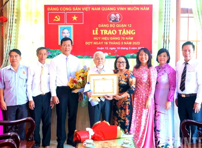 Lãnh đạo Quận ủy quận 12 trao Huy hiệu 70 tuổi Đảng cho ông Đặng Văn Đời. Ảnh: MẠNH TÂN