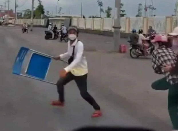 Người thanh niên cầm ghế sắt chặn xe cứu thương. Ảnh: MXH