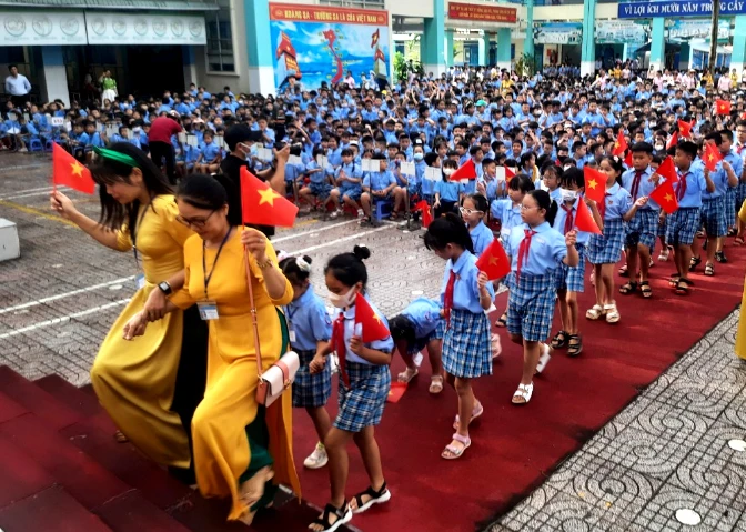 Học sinh lớp một được cô giáo và hoc sịnh lớp năm hướng dẫn vô lớp. Ảnh: TRẦN NGỌC