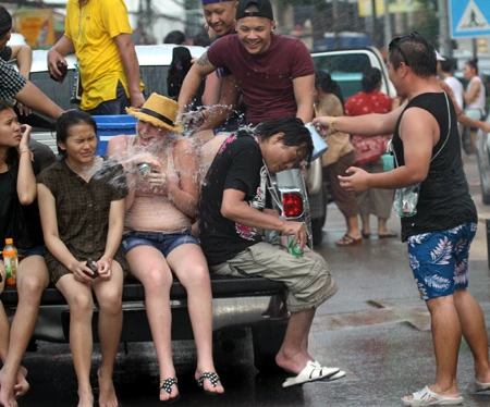 Người phụ nữ nước ngoài được tắm mình khi những làn nước xối ướt trên người.