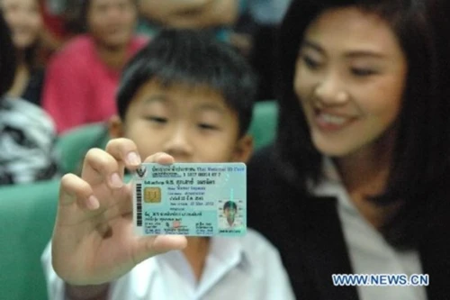 Thailand's elected prime minister Yingluck Shinawatra (R, Back) accompanies her son Supasek Amornchat (L, Back) to acquire an identification card for him in Bangkok, Thailnd, July 11, 2011. A new law which requires Thai citizens to have an ID card beginning at the age of seven became effective on July 10, 2011. (Xinhua/Rachen Sageamsak)