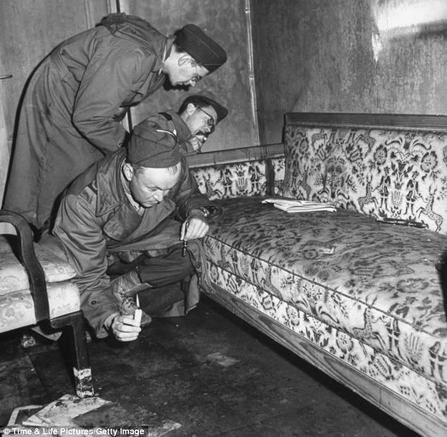 Phóng viên chiến trường kiểm tra ghế sofa dính máu trong căn hầm. Họ cho rằng đây có thể là máu của Hitler bắn ra sau khi trùm phát xít tự sát.