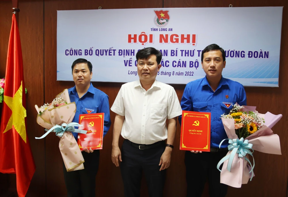 Phó Bí thư Thường trực Tỉnh ủy Nguyễn Thanh Hải trao quyết định và tặng hoa chúc mừng anh Trần Hải Phú (bên phải) và anh Phạm Văn Hậu. Ảnh: XUÂN THỊNH