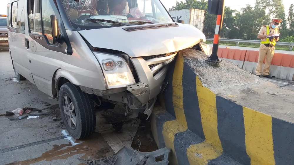 Phần đầu ô tô khách đã dính chặt vào ụ bê tông trạm thu phí cao tốc. Ảnh: Đức Thịnh