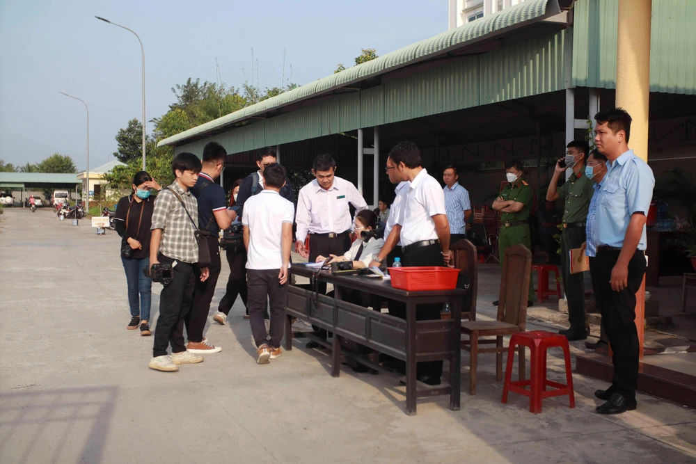 Các phóng viên xuất trình thẻ Nhà báo và được lực lượng an ninh kiểm tra trước khi vào tòa. Ảnh: HUỲNH DU