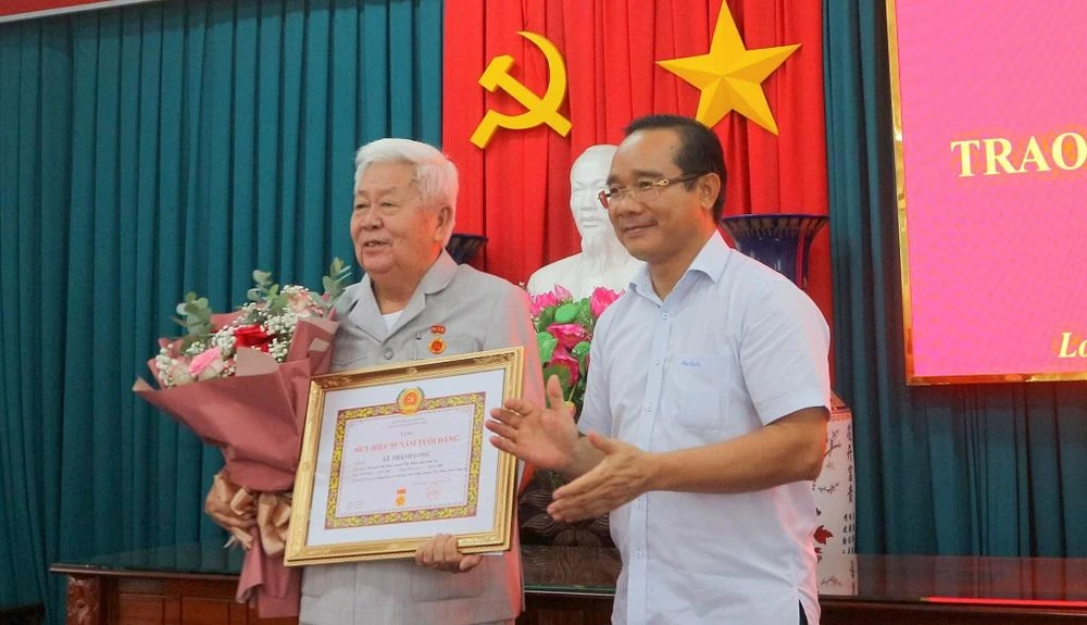 Bí thư Tỉnh ủy - Nguyễn Văn Được trao Huy hiệu 55 năm tuổi Đảng cho ông Lê Thanh Long. Ảnh: CTV