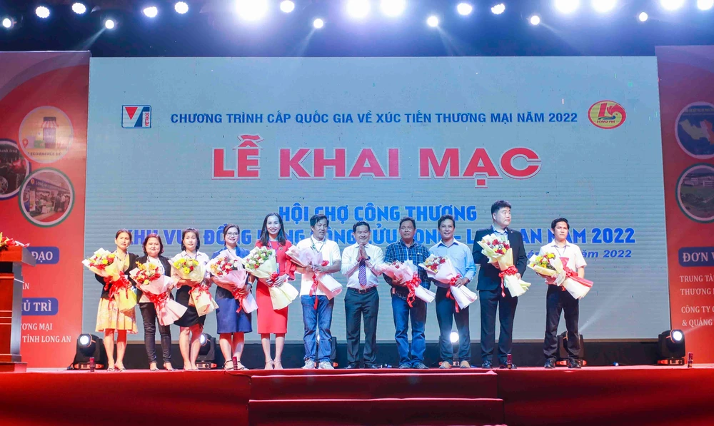 Ban Tổ chức trao tặng hoa cho các đơn vị đồng hành tham gia Hội chợ. Ảnh: HUỲNH DU