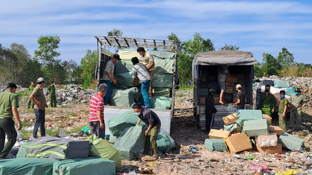 Lực lượng chức năng tiến hành tiến hành tiêu hủy số thuốc lá nhập lậu. Ảnh: NHƯ HUỲNH