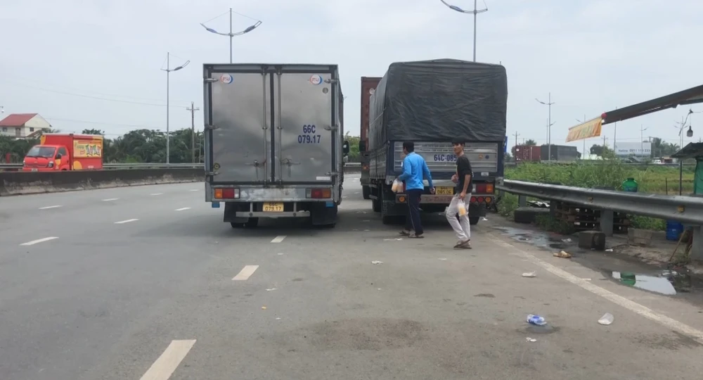 Các phương tiện đậu dọc theo tuyến đường dẫn vào cao tốc TP.HCM - Trung Lương. Ảnh: HUỲNH DU