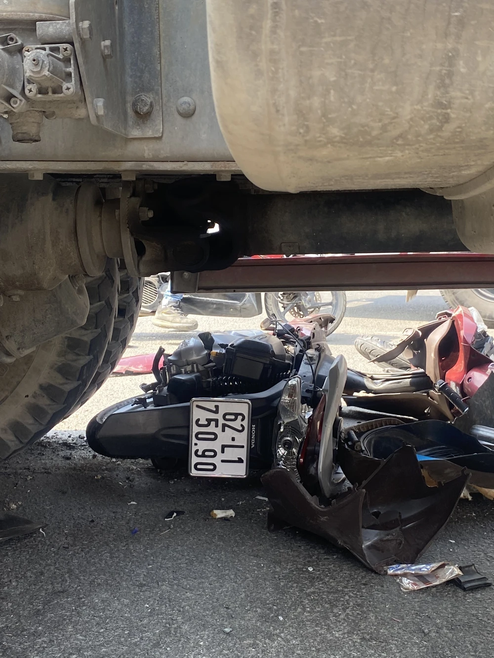 Chiếc xe máy bị lọt vào gầm xe bồn và hư hỏng nặng. Ảnh: CTV Chiếc xe máy bị lọt vào gầm xe bồn và hư hỏng nặng. Ảnh: CTV