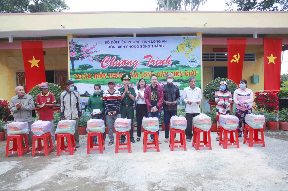 Thiếu tá Nguyễn Xuân Linh - Chính trị viên Đồn Biên phòng Sông Trăng trao quà cho hộ gia đình chính sách, hộ nghèo biên giới vui xuân, đón tết. Ảnh: HUỲNH DU