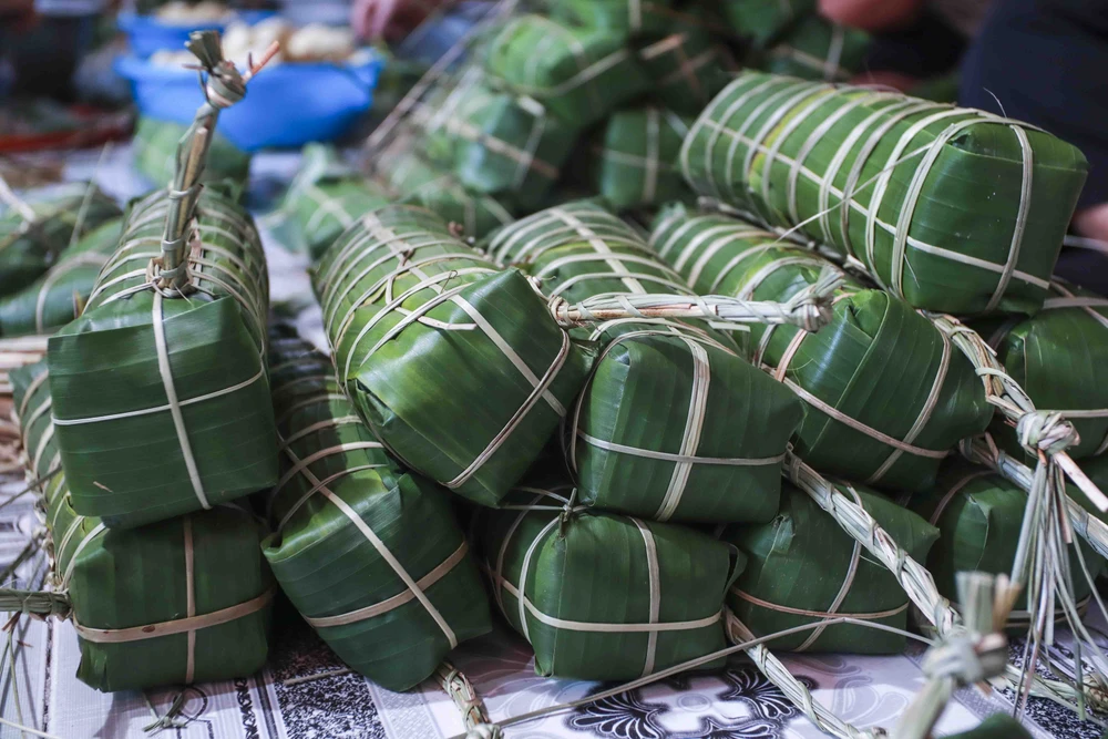 Những đòn bánh tét Vàm Thủ được gói tròn trịa, chỉnh chu trước khi đem vào nấu. Ảnh: HUỲNH DU Xóm bánh tét Vàm Thủ đỏ lửa dịp tết