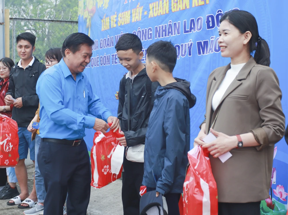 Ông Nguyễn Văn Quí - Chủ tịch LĐLĐ tỉnh trao tặng quà cho gia đình công nhân lên đường về quê đón tết. Ảnh: HUỲNH DU