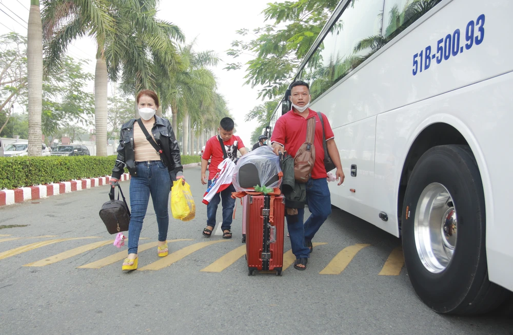 Gia đình Anh Phan Văn Quốc phấn khởi di chuyển hành lý lên xe về quê. Ảnh: HUỲNH DU