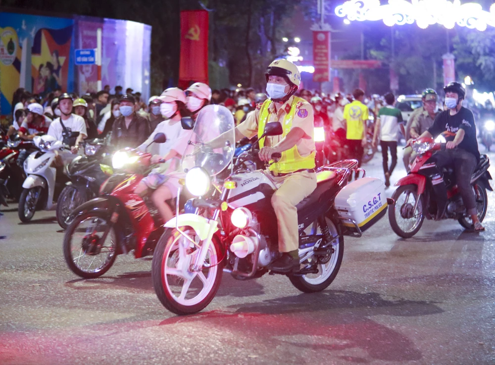 Lực lượng Cảnh sát giao thông tuần tra để người dân giữ trật tự xem bắn pháo hoa. Ảnh: HUỲNH DU