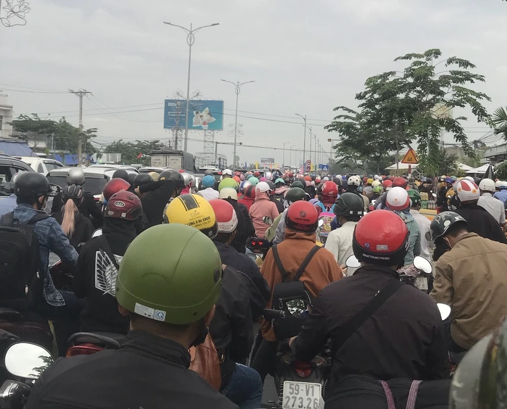 Hàng trăm xe máy đứng chờ cho xe lưu thông từ hướng Mỹ Tho qua Bến Tre. Ảnh: HUỲNH DU