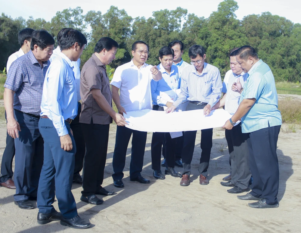Bí thư tỉnh ủy Nguyễn Văn Được (áo trắng chỉ tay) khảo sát tại tuyến đường dự án Vành đai 3. Ảnh: HUỲNH DU