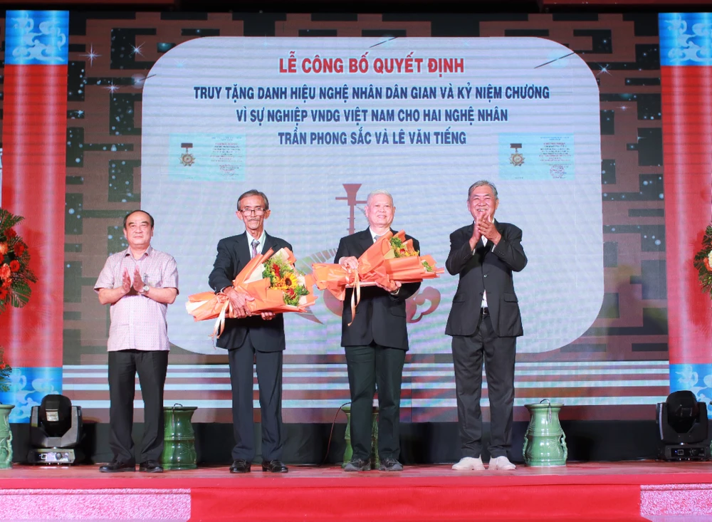 Đại diện gia đình nghệ nhân Trần Phong Sắc và nghệ nhân Lê Văn Tiếng nhận quyết định truy tặng danh hiệu Nghệ nhân dân gian. Ảnh: HUỲNH DU Đại diện gia đình nghệ nhân Trần Phong Sắc và nghệ nhân Lê Văn Tiếng nhận quyết định truy tặng danh hiệu Nghệ nhân dân gian. Ảnh: HUỲNH DU