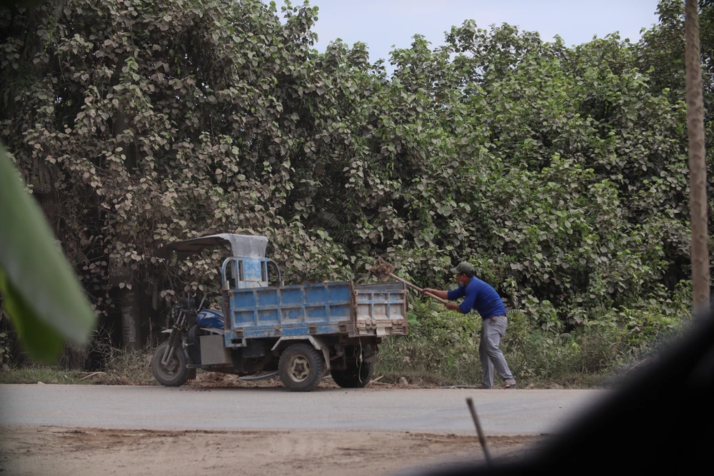 Lớp cát dày đặc được người dân nơi đây dùng xe ba gác xúc chở về nhà. Ảnh: HD