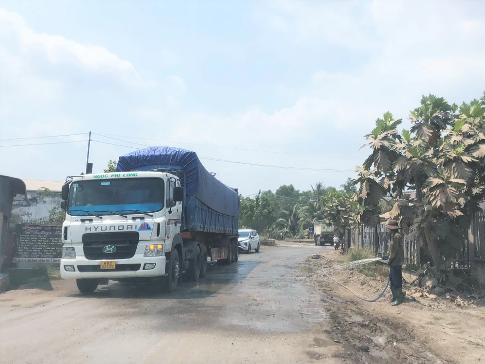 Các đơn vị khai thác ở đây có cử người tưới nước nhưng vẫn không đỡ bụi. Ảnh: HD