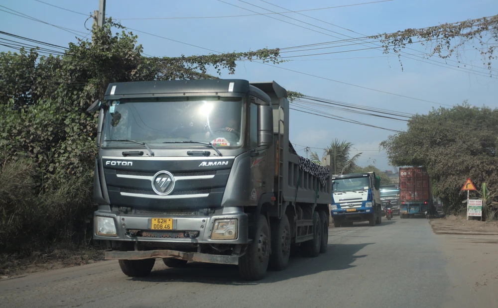 Đoàn xe ben chở cát tung hoành trên đường tỉnh 830, dân khổ sống chung với bụi. Ảnh: HD