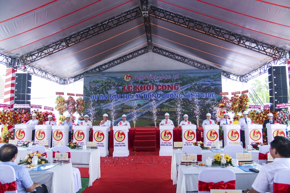 Các đại biểu tham dự bấm nút khởi công dự án đường tỉnh 830E. Ảnh: HUỲNH DU