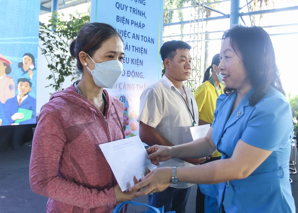 Bà Thái Thu Xương, Phó Chủ tịch Tổng LĐLĐ Việt Nam, trao quà cho công nhân, lao động gặp khó khăn. Ảnh: HUỲNH DU