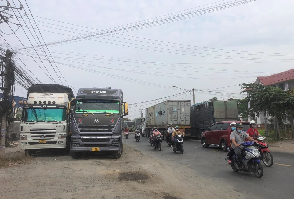 Rất nhiều xe trọng tải lớn đậu 2 bên tuyến quốc lộ 62 lấn chiếm hành lang ATGT. Ảnh: DK