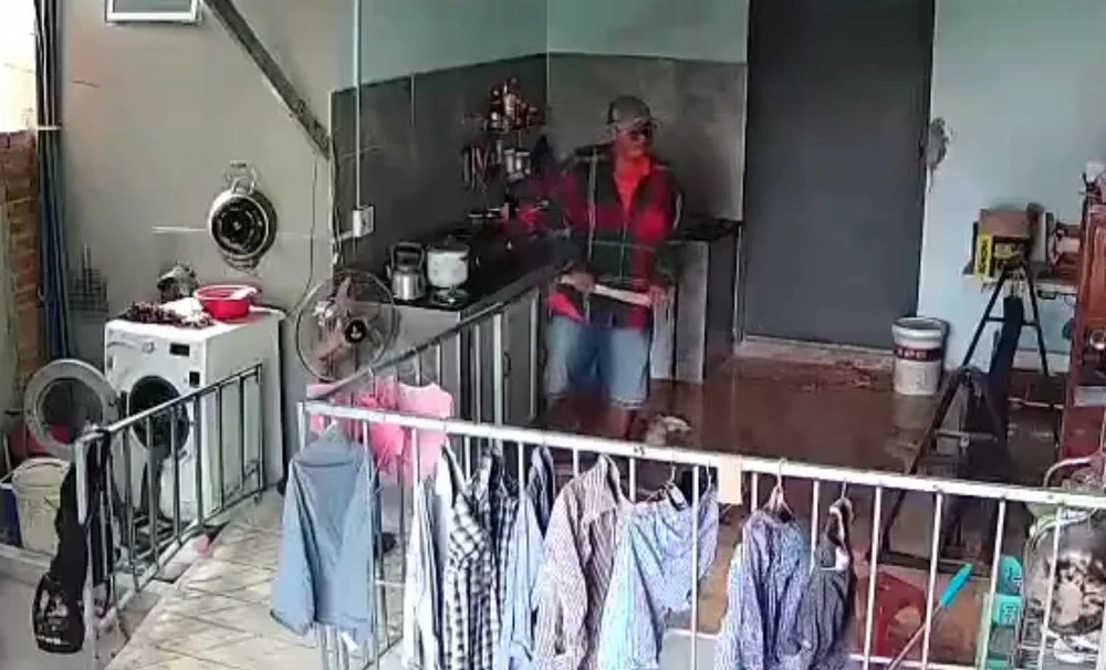 Camera ghi lại cảnh người đàn ông đi vào nhà la lối lớn tiếng và dùng dao đập cửa nhà bà Dưa. Ảnh: Cắt từ clip