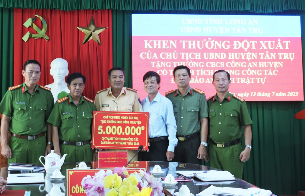 Chủ tịch UBND huyện Tân Trụ Trịnh Phước Trung tặng thưởng đột xuất cho cán bộ, chiến sĩ Công an huyện vì có thành tích trong công tác bảo đảm an ninh, trật tự. Ảnh: THANH MỸ