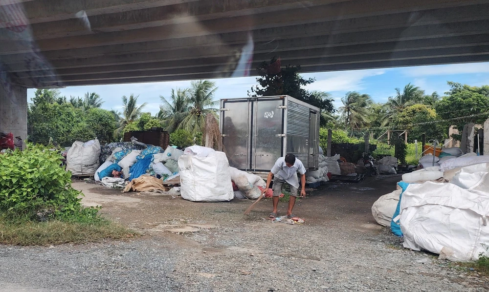 Hàng rào cao tốc bị cắt bỏ để tập kết phế liệu phía dưới gầm đường cao tốc. Ảnh: ĐT