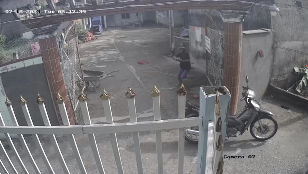 Camera ghi lại cảnh Tiến nhảy lò cò vào trộm máy hàn điện rồi ra xe tẩu thoát. Ảnh cắt từ clip