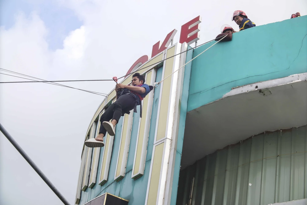 Lực lượng cứu hộ nhanh chóng đưa người từ trên tòa nhà xuống bằng dây cáp. Ảnh: HD