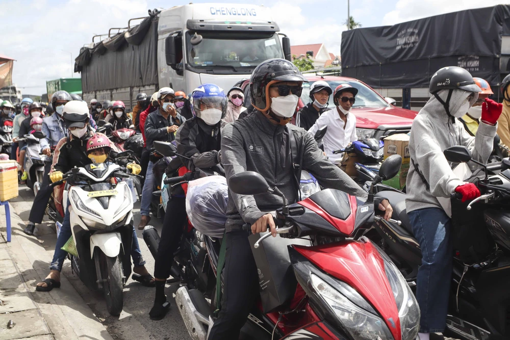 Hàng ngàn người đội nắng trở về miền Tây vào sáng 1-9. Ảnh: HUỲNH DU