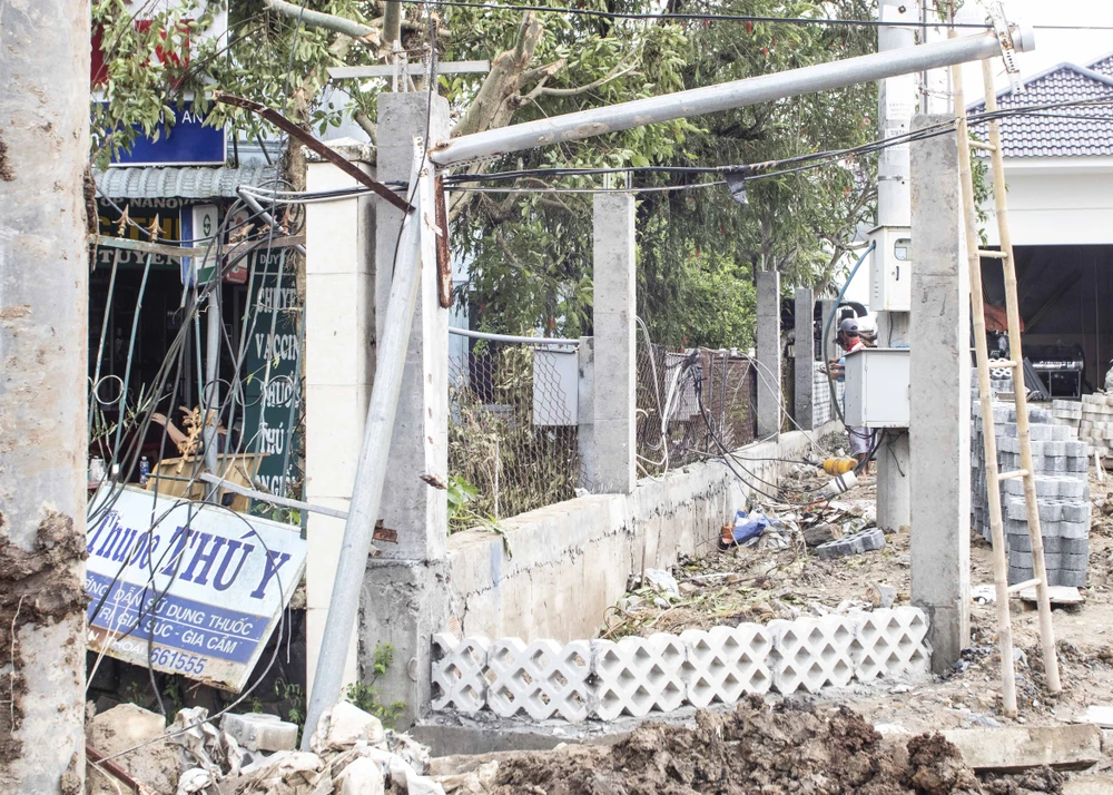 Các bảng quảng cáo bị cơn lốc xoáy làm ngã xuống, nằm sát mặt đất. Ảnh: HUỲNH DU