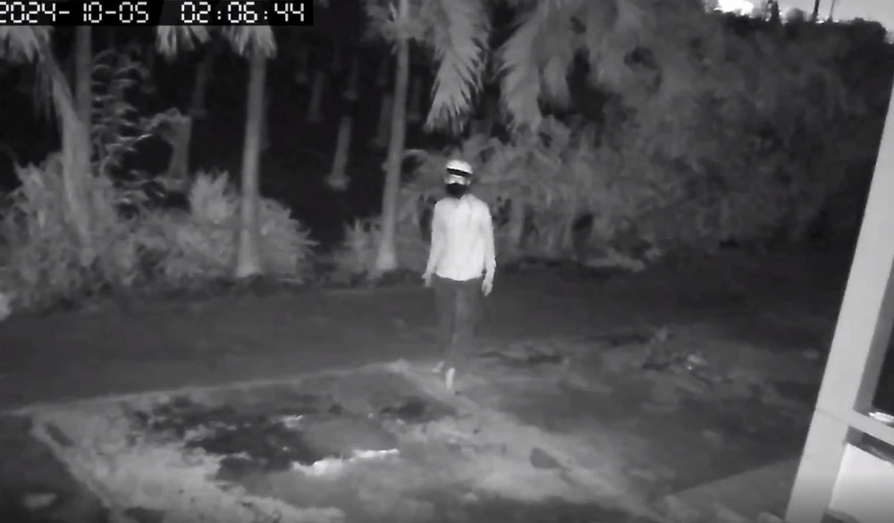 Một trong ba thanh niên quan sát nhà của chị N. trước khi bẻ khóa đột nhập. Ảnh: Cắt từ clip