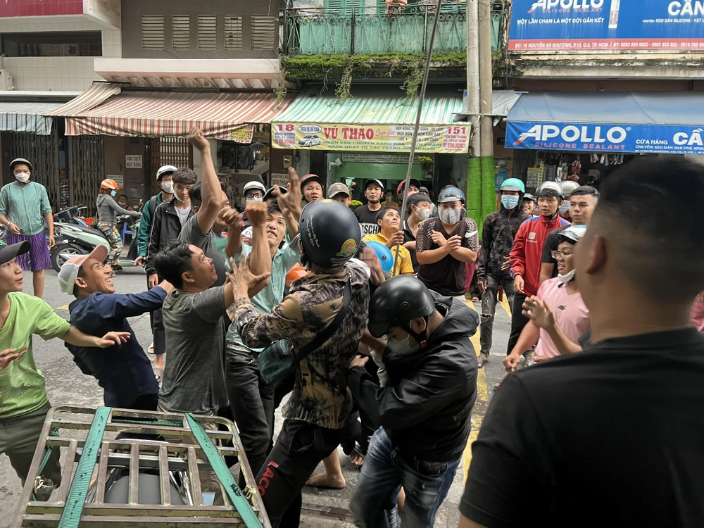 Hàng chục thanh niên chen lấn, tranh giành những tờ tiền lẻ được gia chủ ném ra đường sau lễ cúng tại số nhà 15, đường Nguyễn An Khương (quận 5, TP.HCM).