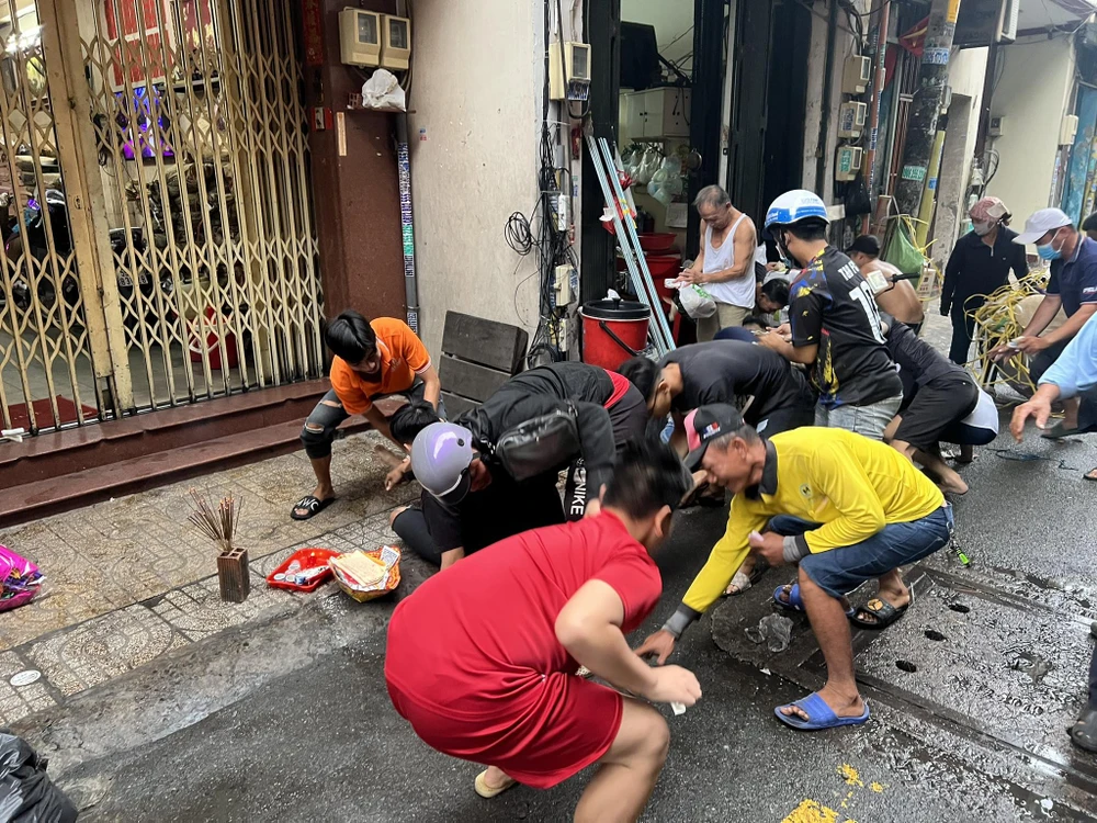 Khoảng chừng 15 người đang cúi nhặt tiền tại số nhà 98, Nguyễn An Khương (quận 5, TP.HCM). Chị Trang Thị Cẩm Hà (47 tuổi) cho biết: "Nhà tôi chuyên sản xuất, kinh doanh đinh, ốc nên hằng năm vào dịp rằm tháng 7 đều làm lễ cúng cô hồn và rải tiền mong nhận được bình an, buôn bán phát tài".